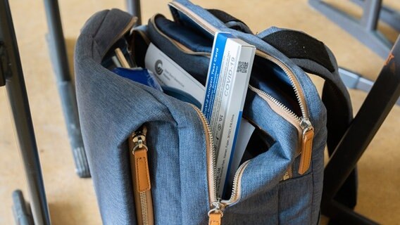 Ein Corona-Selbsttest ragt aus der Tasche eines Schülers in einem Klassenraum der Robert Bosch Gesamtschule Hildesheim. © picture alliance/dpa/Julian Stratenschulte Foto: Julian Stratenschulte