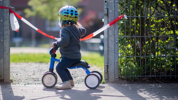 Ein Kind vor einem abgesperrten Spielplatz. © dpa-Bildfunk Foto: Julian Stratenschulte
