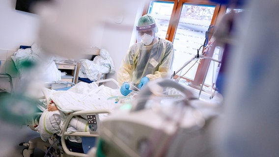 Ein Arzt in Schutzkleidung behandelt einen Coronapatienten. © Picture Alliance Foto: Kay Nietfeld