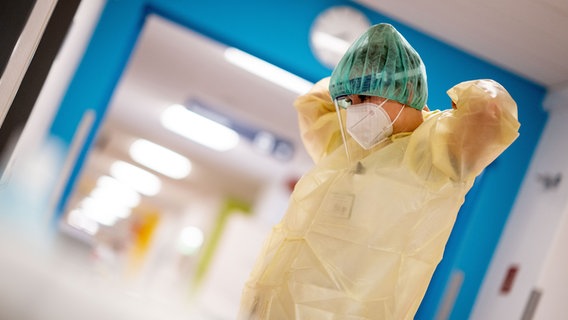 Eine Krankenpflegerin zieht eine Schutzausrüstung an. © Picture Alliance Foto: Kay Nietfeld