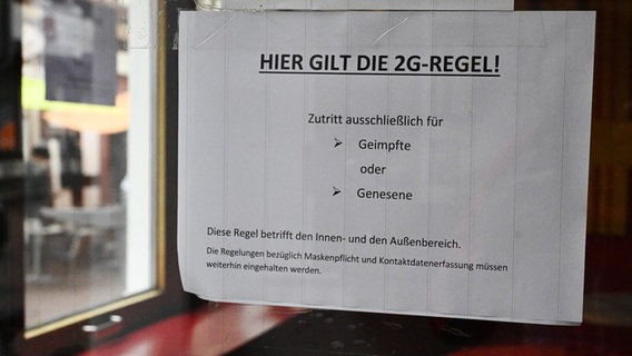 Ein Schild was auf die 2G-Regel hinweist hängt in einem Cafe in der Göttinger Innenstadt. © picture alliance/dpa/Swen Pförtner Foto: Swen Pförtner