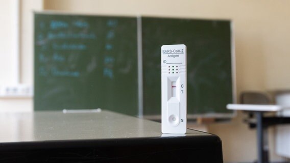Ein Corona-Schnell-Test steht in einem Klassenzimmer. © picture alliance Foto: Julian Stratenschulte