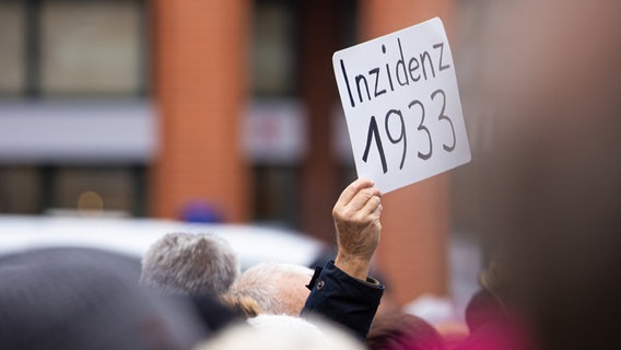 Der Schriftzug «Inzidenz 1933» ist auf einem Schild zu lesen, das ein Mann bei einer AfD-Kundgebung in Hannover hochhält. © dpa-Bildfunk Foto: Michael Matthey