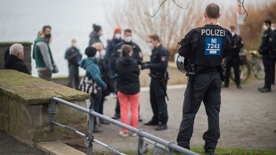 Polizisten stehen vor einer Menschengruppe an der Löwenbastion am Maschsee. © dpa Foto: Julian Stratenschulte