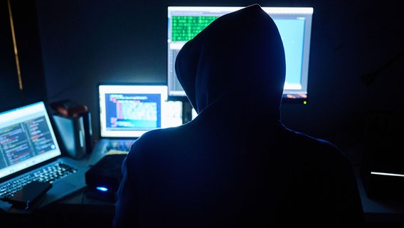 Fiktive html-Seiten und Hacker-Programme sind auf Bildschirmen zu sehen, während ein Mann seinen Hände auf der Tastatur hat. Fiktive html-Seiten und Hacker-Programme sind auf Bildschirmen zu sehen, während ein Mann seinen Hände auf der Tastatur hat. © picture alliance/dpa | Annette Riedl Foto: Annette Riedl