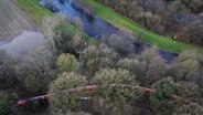 Niedersachsen, Oldenburg: Mitarbeiter von THW und der Feuerwehr Oldenburg befüllen Elemente eines mobilen Notdeichs mit Wasser (Aufnahme mit Drohne). Der mobile Deich wird neben dem Parkfriedhof Bümmerstede errichtet. ©  Christian Charisius/dpa Foto:  Christian Charisius/dpa