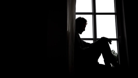 Ein Mann sitzt vor einem Fenster. © picture alliance/dpa Foto: Sina Schuldt