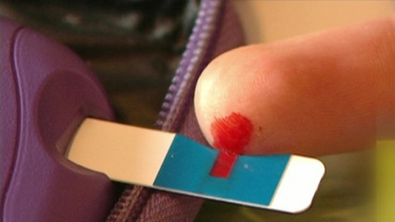 Ein Bluttropfen wird auf einen Streifen zur Blutzuckermessung gegeben. © NDR 