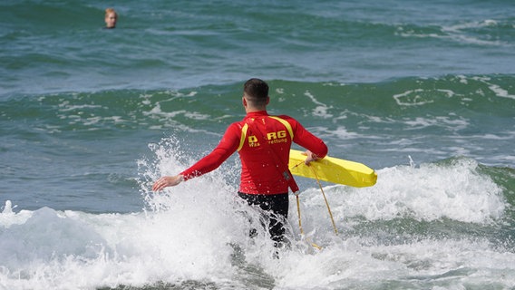 Ein Rettungsschwimmer rennt ins Wasser. © Marcus Brandt/dpa Foto: Marcus Brandt