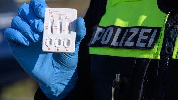 Ein Polizist der Polizei Hildesheim zeigt einen positiven Drogen-Test auf THC (Cannabis) eines Autofahrers. © picture alliance/dpa/Julian Stratenschulte Foto: Julian Stratenschulte