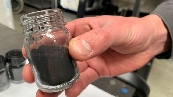 Black mass - as a powder - in a glass at the Duesenfeld company in Wendeburg near Peine.  © NDR Photo: Sabine Hausherr