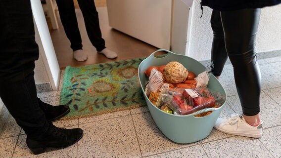 Mitarbeiterinnen des Malteser Hilfsdienstes stehen mit Lebensmitteln vor einer Haustür. © picture alliance/dpa Foto: Patrick Seeger