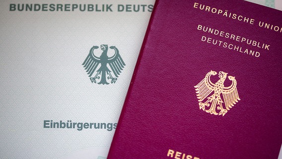 Eine Einbürgerungsurkunde der Bundesrepublik Deutschland (l) und ein deutscher Reisepass liegen auf einem Tisch. © picture alliance/dpa | Fernando Gutierrez-Juarez Foto: Fernando Gutierrez-Juarez
