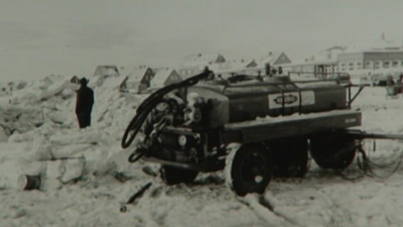 Ein Mann und ein Fahrzeug im Schnee  