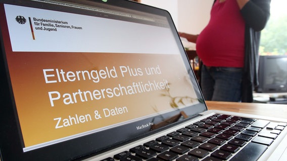 Eine schwangere Frau steht neben einem Laptop, auf dem ein Antragsformular für Elterngeld geöffnet ist. © picture alliance/dpa/Bodo Marks Foto: Bodo Marks