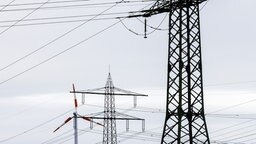 Ein Windrad steht neben dem Mast einer Hochspannungsleitung. © picture alliance/dpa | Philipp von Ditfurth Foto: Philipp von Ditfurth