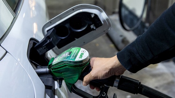 Ein Autofahrer tankt ein Auto mit Benzin. © dpa Foto: Carsten Koall