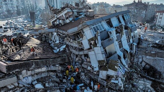 Türkei, Kahramanmaras: Ein Mehrfamilienhaus zerstört und in Schieflage. Rettungsteams versuchen Überlebende in dem durch die Erdbeben zerstörten Gebäuden zu finden. © Ahmet Akpolat/DIA/AP/dpa Foto: Ahmet Akpolat/DIA/AP/dpa