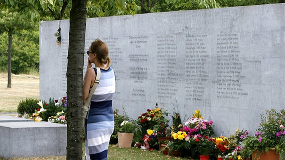 Eine Frau steht in Eschede zum zehnten Jahrestag des ICE-Unglücks an der Gedenkstätte. © dpa 