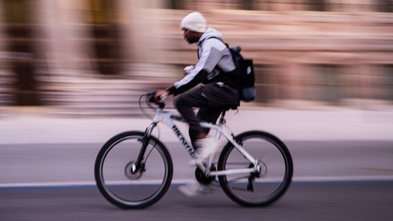 Ein Radfahrer fährt am frühen Morgen auf einem Radschnellweg. © dpa Foto: Swen Pförtner