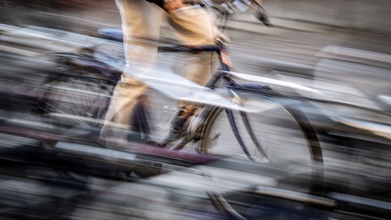 Eine Person auf einem Fahrrad (Langzeitbelichtung). © Sina Schuldt/dpa Foto: Sina Schuldt/dpa