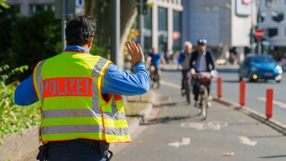 Ein Polizist winkt Radfahrer für eine Kontrolle raus. Ein Polizist winkt Radfahrer für eine Kontrolle raus. © picture alliance/dpa Foto: Andreas Arnold