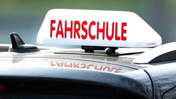 Ein Dachschild mit der Aufschrift "Fahrschule" ist auf einem Fahrschulauto befestigt. © dpa-Bildfunk Foto: Swen Pförtner
