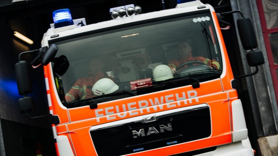 Ein Feuerwehrauto fährt mit Blaulicht aus einer Feuerwache heraus. © NDR Foto: Julius Matuschik
