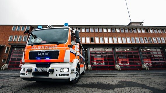 Ein Feuerwehrauto steht vor einer Feuerwache. © NDR Foto: Julius Matuschik