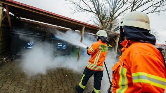 Zwei Feuerwehrleute löschen einen Brand. © NDR Foto: Julius Matuschik