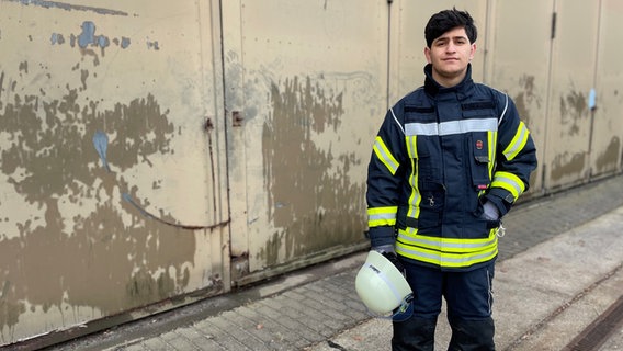 Jagar Karim, 19 Jahre alt, aus dem Irak, seit fünf Jahren in Deutschland, trägt eine Feuerwehr-Uniform. © NDR Foto: Catherine Grim