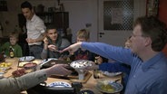 Die Brüder Abd sitzen am Silvesterabend mit Familie Berndt beim Abendessen zusammen. © NDR 
