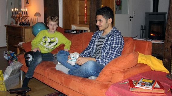 Gastbruder Emil beobachtet, wie Abdullah ein Geschenk auspackt. © NDR Foto: Andreas Rabe