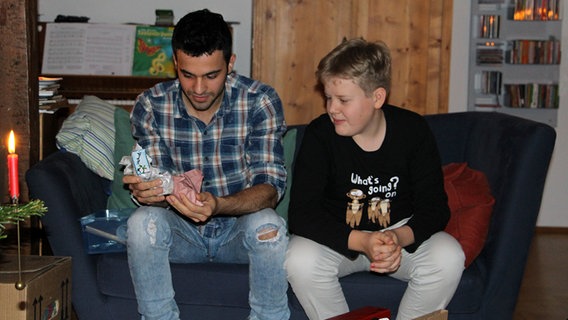 Gastbruder Otto beobachtet, wie Mohammad aus dem Irak ein Geschenk auspackt. © NDR Foto: Andreas Rabe