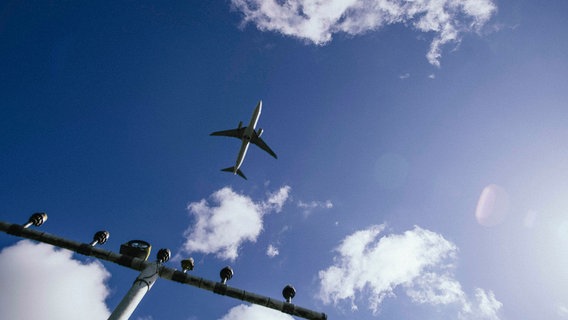 Bei blauem Himmel und Sonnenschein steigt ein Flugzeug an einem Flughafen in Niedersachsen in die Luft auf. © NDR Foto: Julius Matuschik