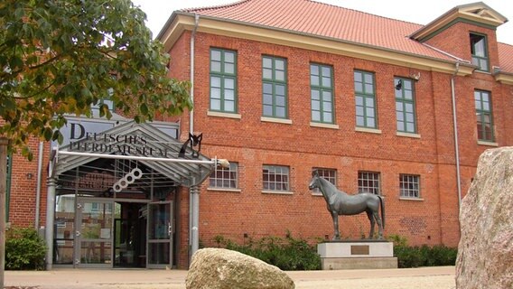 Ein großes Haus aus rotem Klinker, davor steht eine Pferdestatue. © Landkreis Verden 