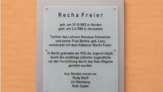 An einer aprikotfarbenen Wand hängt ein graues Schild. © Kaja Schierl Foto: Kaja Schierl