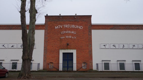 Ein roter Klinkerbau, der zum Teil weiß verputzt ist, steht an einer Straße. © NDR Foto: Andrea Heußinger