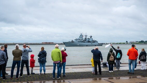 Angehörige winken, während die Fregatte "Schleswig-Holstein" aus dem Hafen fährt. © dpa Foto: Sina Schuldt