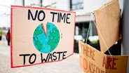 Auf einem Schild steht "no time to waste". © Picture Alliance Foto: Hauke-Christian Dittrich