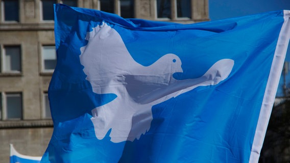 Flagge mit Friedenstaube: Das Symbol der Friedensbewegung. © IMAGO / FotoPrensa 