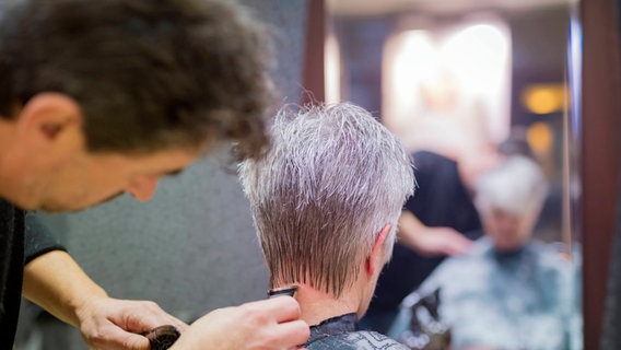 Einer älteren Kundin beim Friseur wird der Nacken ausrasiert. © picture alliance / Westend61 | Frank Röder Foto: picture alliance / Westend61 | Frank Röder