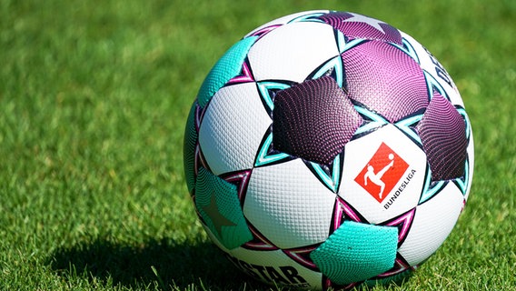 Ein Ball der Marke Derbystar Bundesliga Brillant Aps by Select liegt auf dem Rasen und zeigt das Logo der Bundesliga. © picture alliance/foto2press Foto: Oliver Zimmermann
