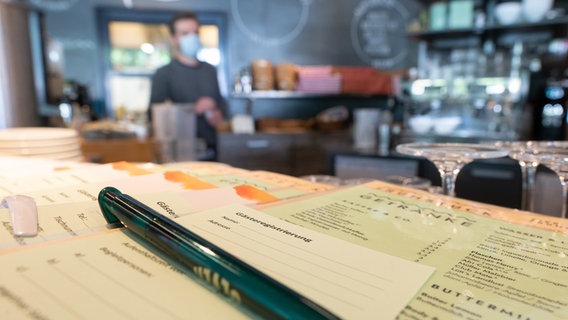 Hannover: Zettel für die Gästeregistrierung liegen im Café Mezzo an der Lister Meile. © dpa-Bildfunk Foto: Julian Stratenschulte