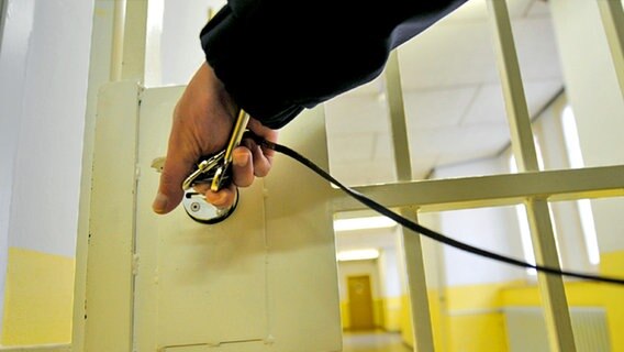 Eine Hand schließt eine Gefängnistür auf. © dpa - Report Foto: Uwe Zucchi