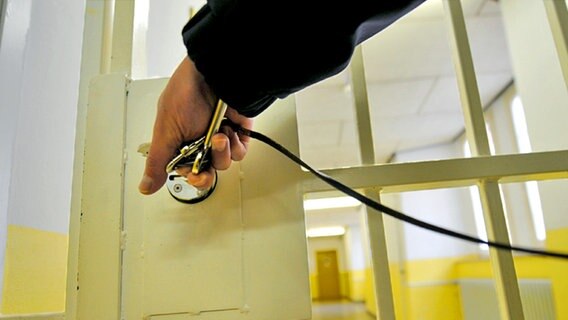 Eine Hand schließt eine Gefängnistür auf. © dpa - Report Foto: Uwe Zucchi