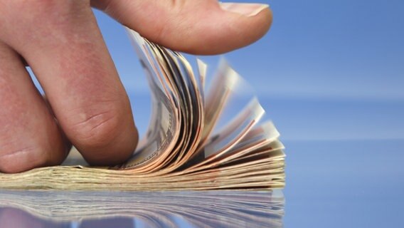 Ein Erwachsener blättert in einem Bündel Geld. © fotolia Foto: Joachim Wendler
