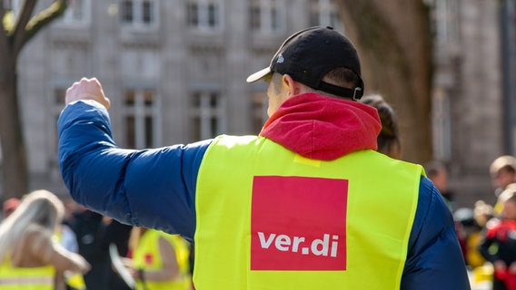 Ein Mitglied von Ver.di steht am Rande einer Demonstration. © picture alliance/Eibner-Pressefoto Foto: Eibner/Fabian Steffens