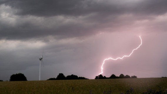 Ein Blitz schlägt während eines Gewitters neben einem Windrad ein © picture alliance/dpa Foto: Julian Stratenschulte
