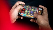 Auf einem Smartphone wird ein Online-Spiel gespielt. © dpa - picture alliance Foto: Sina Schuldt